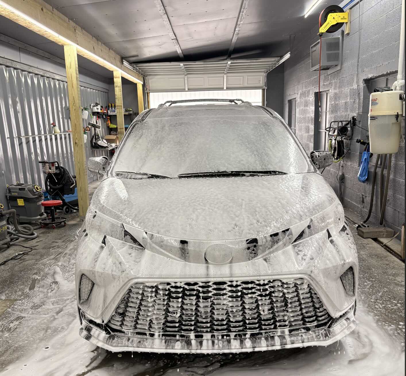 Minivan covered in snow foam in the Frankford Auto Center wash bay